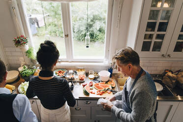 High angle view of senior man and woman preparing dinner at kitchen counter - MASF19153