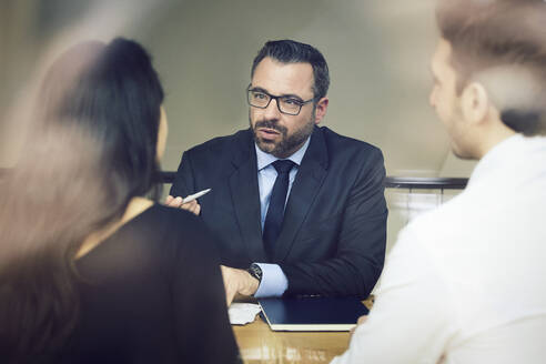 Selbstbewusster reifer männlicher Anwalt, der mit Kunden im Büro diskutiert - MASF19308