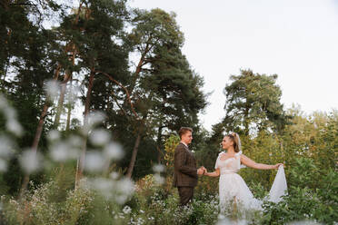 Groom holding hand of the bride in a forest - ADSF00170