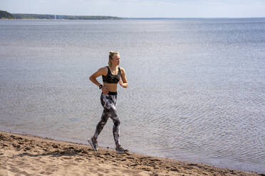 Young woman jogging at beach - VPIF02577