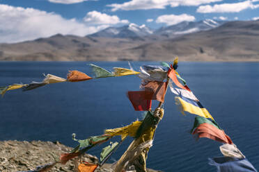 Colorful prayer flags hanging against alpine lake - EHF00486