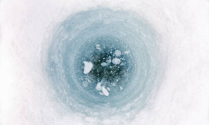 Nahaufnahme eines Eisangellochs auf einem zugefrorenen See in Vasterbottens Lan, Schweden. - CUF55712