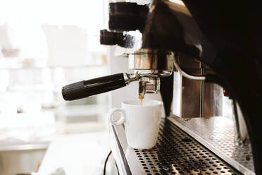 Kaffee wird aus einer Maschine in einer Bäckerei in eine Tasse gegossen - EBBF00394