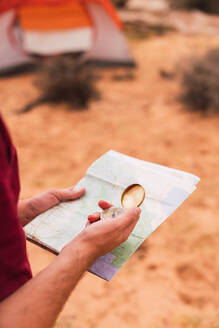 Crop Mann hält Karte und Retro-Kompass, während stehend auf unscharfen Hintergrund der majestätischen Wüste - ADSF00233