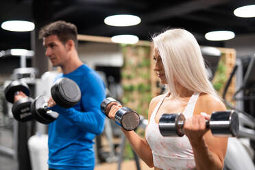 Mann und Frau trainieren im Fitnessstudio - ADSF00260