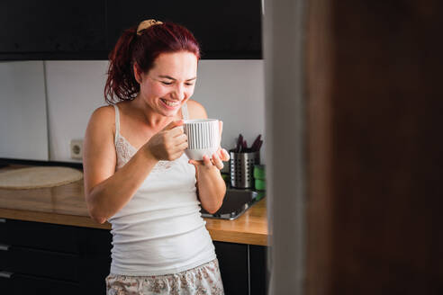 Frau trinkt Kaffee in der Küche - ADSF00277