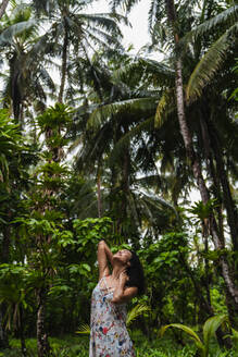 Junge Frau im Kleid zwischen tropischen Wäldern - ADSF00294
