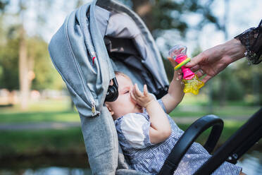 Crop hand comforting baby in carriage - ADSF00309