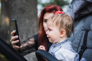 Mutter zeigt dem verärgerten Baby ihr Smartphone - ADSF00310