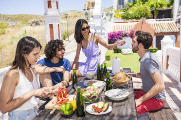 Junge multiethnische Freunde beim Brunch auf der Terrasse an einem sonnigen Tag - JSMF01626