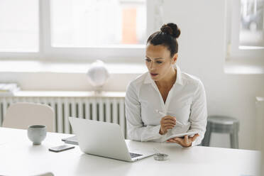 Businesswoman using digital tablet and laptop on desk in home office - JOSEF01301