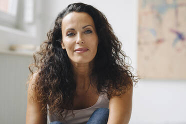 Close-up of beautiful woman with wavy hair sitting at home - JOSEF01336