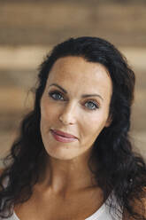 Close-up of smiling mid adult woman against wall at home - JOSEF01360