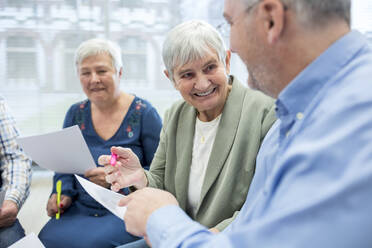Senioren in einer Therapiegruppe in einem Seniorenheim, die Notizen auf Zetteln notieren - WESTF24604
