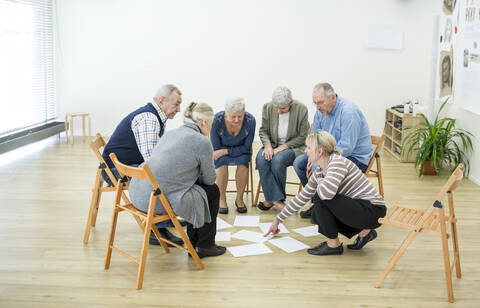 Group of seniors in retirement home evaluating result of group therapy stock photo