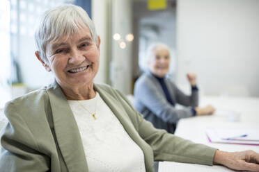 Glückliche Seniorin, die an einem Kurs für Seniorenbildung teilnimmt - WESTF24667