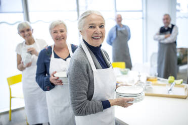 Eine Gruppe von Senioren deckt den Tisch für das Kaffeekränzchen im Altersheim - WESTF24685