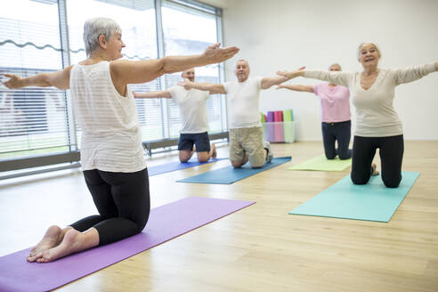 Gruppe aktiver Senioren, die gemeinsam Yoga praktizieren - WESTF24700