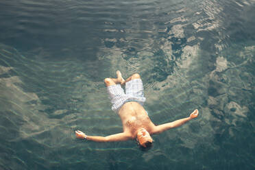 Man swimming in blue water - ADSF00428