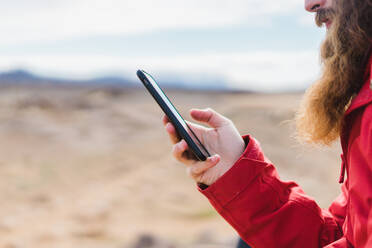 Crop-Mann mit Smartphone am Geysir - ADSF00480