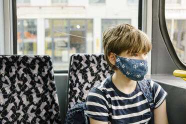 Junge mit Schutzmaske in der Straßenbahn - MMFF01287