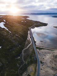 Russia, Murmansk Oblast, Teriberka, Aerial view of coastal road at sunset - KNTF04916