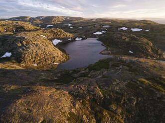 Russia, Murmansk Oblast, Teriberka, Aerial view of lakes surrounded by rocky hills at dusk - KNTF04921