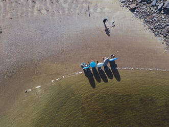 Luftaufnahme von Surfern am sandigen Ufer des Flusses Teriberka - KNTF04940
