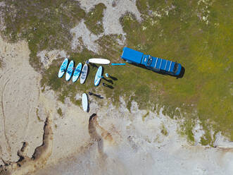 Luftaufnahme von Surfern, die sich am sandigen Flussufer vorbereiten - KNTF04946