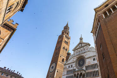 Italien, Provinz Cremona, Cremona, Klarer Himmel über dem Baptisterium von Cremona und dem Glockenturm von Torrazzo - MCVF00498