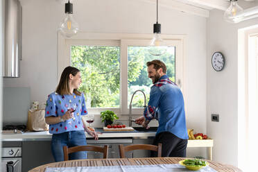 Smiling mid adult couple talking in kitchen at home - EIF00028