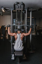 Black man exercising on machine in gym - ADSF00554