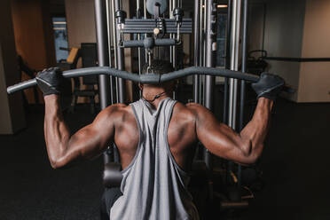 Black man exercising on machine in gym stock photo