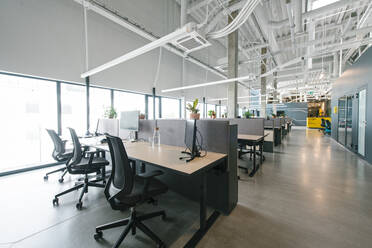 Inside shot of new open space office with colorful furniture on workplace and light from windows - ADSF00579