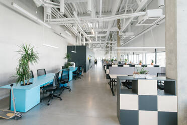 Inside shot of new open space office with colorful furniture on workplace and light from windows - ADSF00580