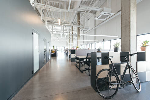 Innenaufnahme von modernen Großraumbüro Interieur in weißen und schwarzen Farben mit Fahrrad im Flur geparkt - ADSF00582