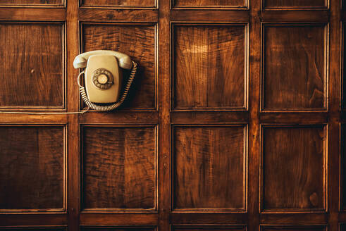 Komposition von Vintage-Telefon hängen auf hölzernen verzierten Wand - ADSF00618