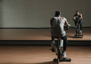 Black guy making selfie on exercise bike in gym - ADSF00652