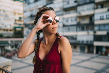 Hübsches rothaariges Mädchen mit Zöpfen und Sonnenbrille in der Stadt Madrid, Spanien. - ADSF00701