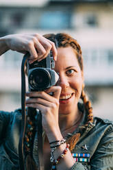 Hübsches rothaariges Mädchen mit Zöpfen beim Fotografieren in der Stadt Madrid, Spanien. - ADSF00721
