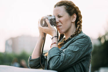 Pretty redhead girl with braids taking pictures. It is in the city of Madrid Spain. - ADSF00722