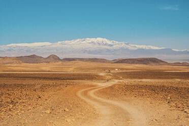 Malerischer Blick auf die Landstraße zwischen Wüste mit wildem Land und blauem Himmel in Marrakesch, Marokko - ADSF00749