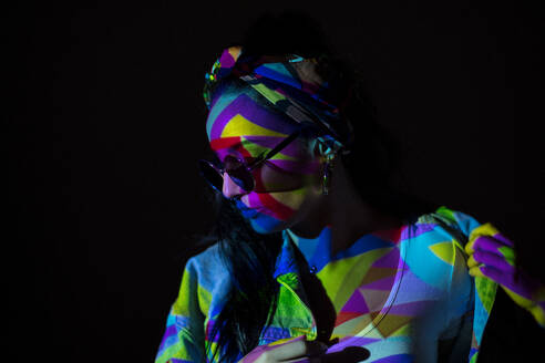 Pretty stylish woman in sunglasses with geometric colorful light on face. - ADSF00857