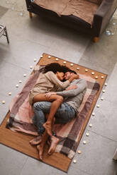 Multiethnic couple kissing on floor - ADSF00869