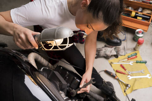 Frau repariert Motorrad - FMOF00998