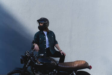 Frau mit Helm am Motorrad stehend - FMOF01032