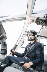 Attraktive Pilotin im Hubschrauber sitzend - ADSF01072