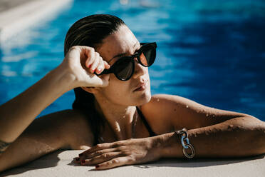 Junge Frau mit Sonnenbrille im Pool - ADSF01110