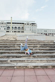 Junge Frau tanzt auf einer Treppe - XLGF00355
