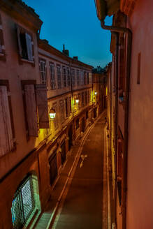 Frankreich, Haute-Garonne, Toulouse, Beleuchtete Gasse in der Abenddämmerung - NGF00588